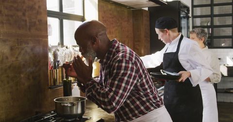 Senior man tasting meal in group cooking class