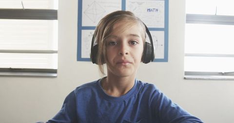 School boy concentrating wearing headphones for learning