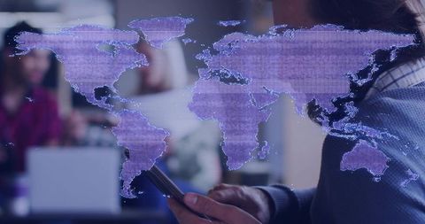 Holding smartphone with holographic world map illustrating global connectivity in office