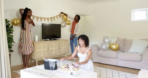Diverse Friends Decorating Living Room for Celebration