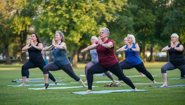 Senior women practicing yoga outdoors in park setting