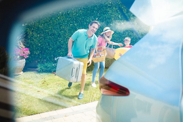 Happy caucasian family with luggage standing on field during picnic seen through car window. unaltered, family, lifestyle, transportation, childhood, leisure activity and weekend activities.