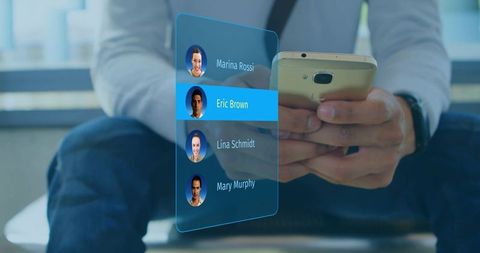 Man holding smartphone viewing holographic augmented reality contact list in casual lounge