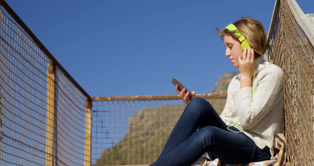 Young woman listening to music with headphones outdoors - Download Free Stock Images Pikwizard.com