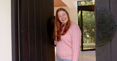 Smiling woman welcoming guests at modern entrance