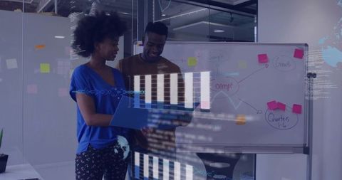 Two Professionals Collaborating Over Data Charts and Whiteboard Brainstorming in Glass Office