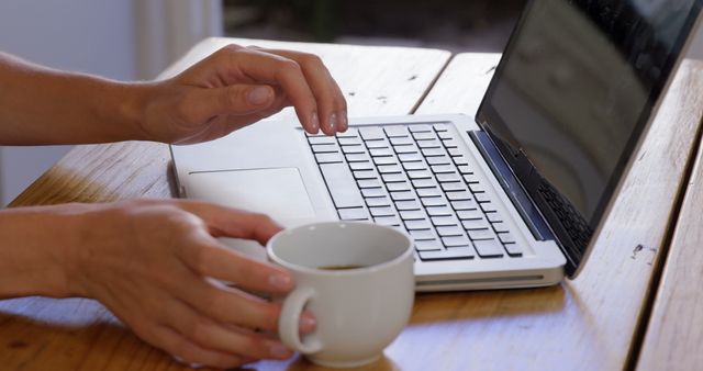 Person Working on Laptop with Coffee on Wooden Table - Download Free Stock Images Pikwizard.com