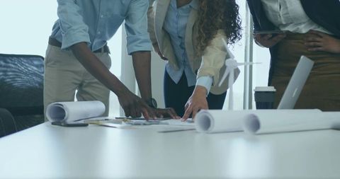 Professionals Collaborating on Architectural Plans in Office Setting