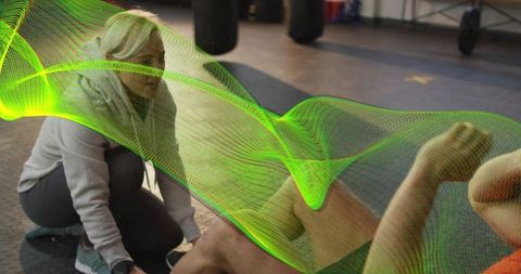 Trainer assisting client doing crunches on mat with neon tech overlay fitness coaching