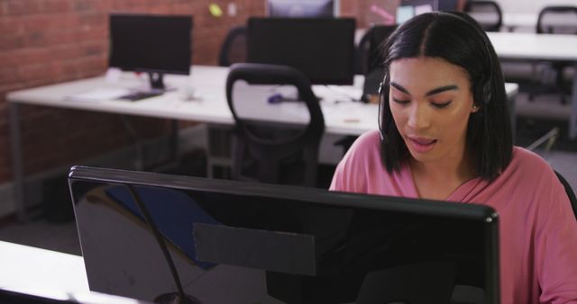 Customer service representative using a computer wearing a headset in office - Download Free Stock Images Pikwizard.com