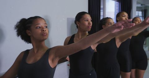 Young Female Dancers Practising at Barre in Ballet Class