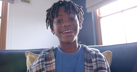 Joyful African American Boy Sitting on Sofa for Video Call at Home