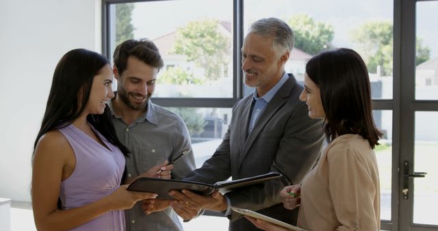 Realtor Presenting Property to Smiling Young Couple - Download Free Stock Images Pikwizard.com