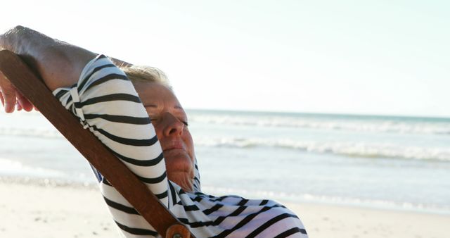 Caucasian senior woman sleeping in sunbed with hands behind head on beach by sea, copy space - Download Free Stock Photos Pikwizard.com