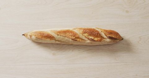 Fresh bakery baguette on wooden surface