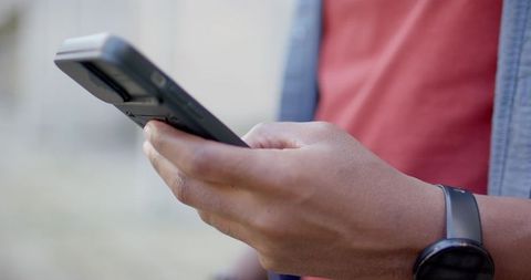 African American Man Holding Smartphone Closeup Wearing Smartwatch and Red T-Shirt