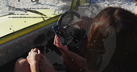 Woman using smartphone while steering sunlit yellow boat with digital globe overlay