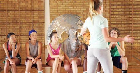 Coach addressing youth basketball team on bench in gym with globe overlay