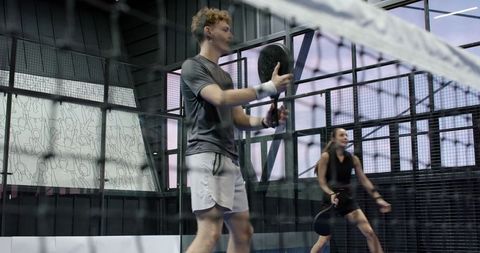 Dynamic Padel Game at Indoor Court with Enthusiastic Players