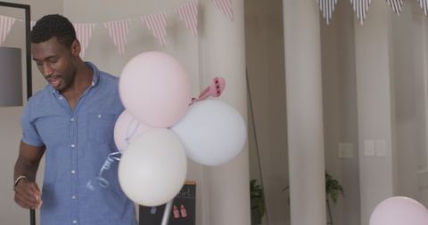 Man Holding Balloons at Home for Festive Celebration