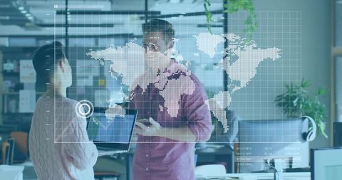 Team collaborating over digital world map visualization and analytics dashboard in open office