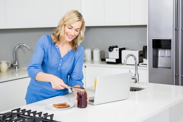 Beautiful woman preparing a slice of bread in kitchen at home