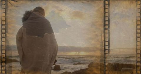 Woman Draped in Blanket Overlooking Ocean at Sunset in Vintage Style