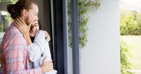 Joyful Embrace Laughter Bonding at Home Near Window