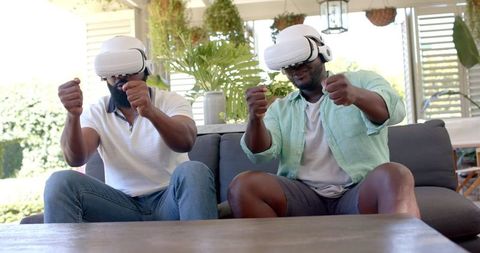 Enthusiastic Friends Experiencing VR Gaming at Home