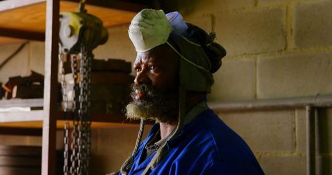 Thoughtful Worker in Foundry Workshop with Protective Gear