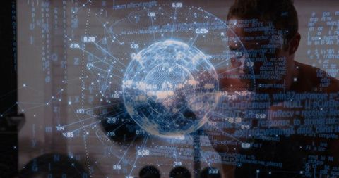Developer examining holographic globe with code overlay in high-tech lab