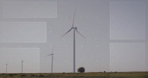 Wind turbine spinning on grassy plain with digital grid overlay and renewable energy