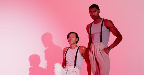 Stylish Diverse Male Friends Posing in Pink-Red Studio Lighting