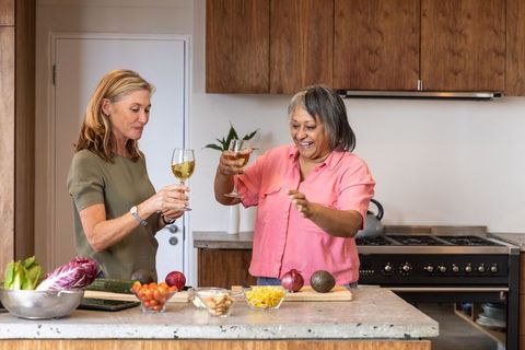 Senior Female Friends Toasting in Modern Kitchen