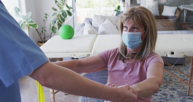 Senior woman engaging in a guided exercise session with a physiotherapist at home, illustrating healthcare and rehabilitation services. Useful for content related to senior care, physical therapy, healthcare professionals, home-based health services, and elderly well-being.