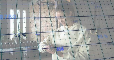 Woman checking smartwatch in loft workspace with data visualization overlay