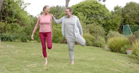 Active Mature Couple Stretching Together Outdoors in Harmony