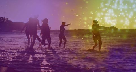 Sunset beach silhouettes running and splashing friends in bikinis with sparkle bokeh