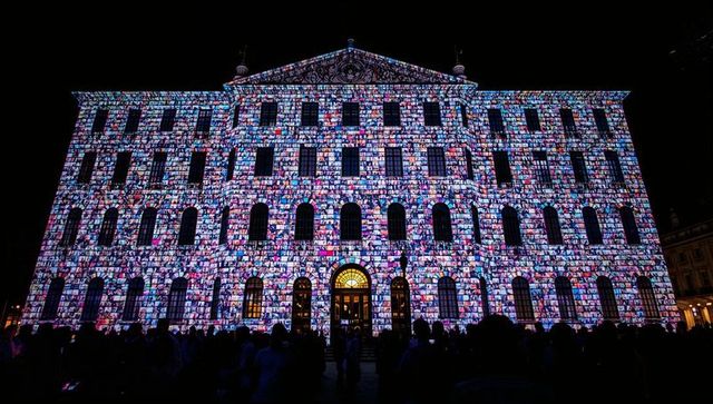 Historic building facade transforming into vibrant mosaic during night projection show
