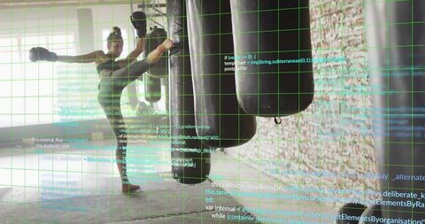 Female athlete delivering high side kick with augmented reality grid in industrial gym