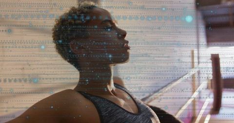 Pausing and breathing at barre with blue digital overlay, athletic woman portrait