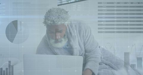 Senior African American Man Analyzing Data on Laptop at Home