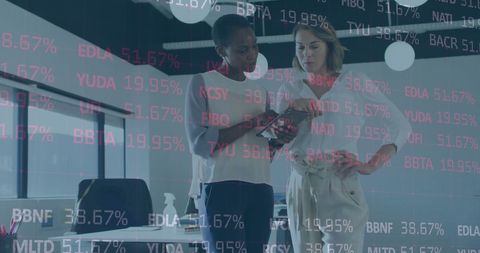 Businesswomen Analyzing Digital Financial Data in Modern Office