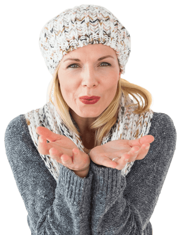 Caucasian woman in warm winter attire blowing on transparent background