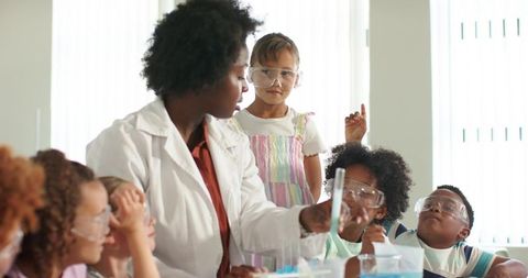 African american science teacher leading chemistry experiment with curious students