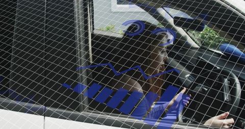 Young woman belted in car interior holding wheel with futuristic blue data overlay
