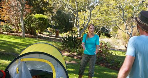 Hiking couple arguing amidst camping tent in forest