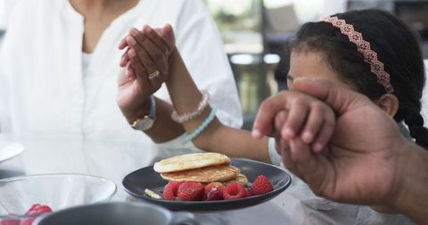 Family Enjoying Breakfast with Pancakes and Raspberries