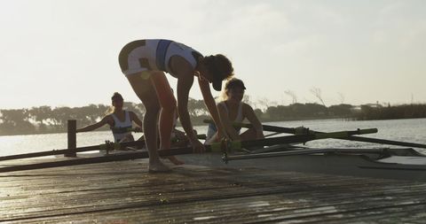 Women Preparing for Sunrise Rowing on Calm Water - Download Free Stock Images Pikwizard.com