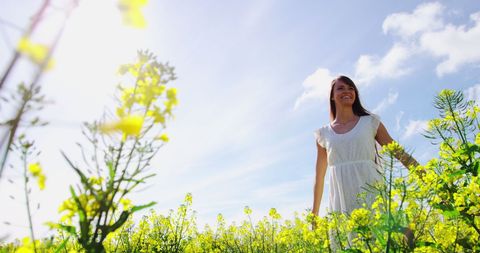 Woman Enjoying Sunlight in Yellow Flower Field